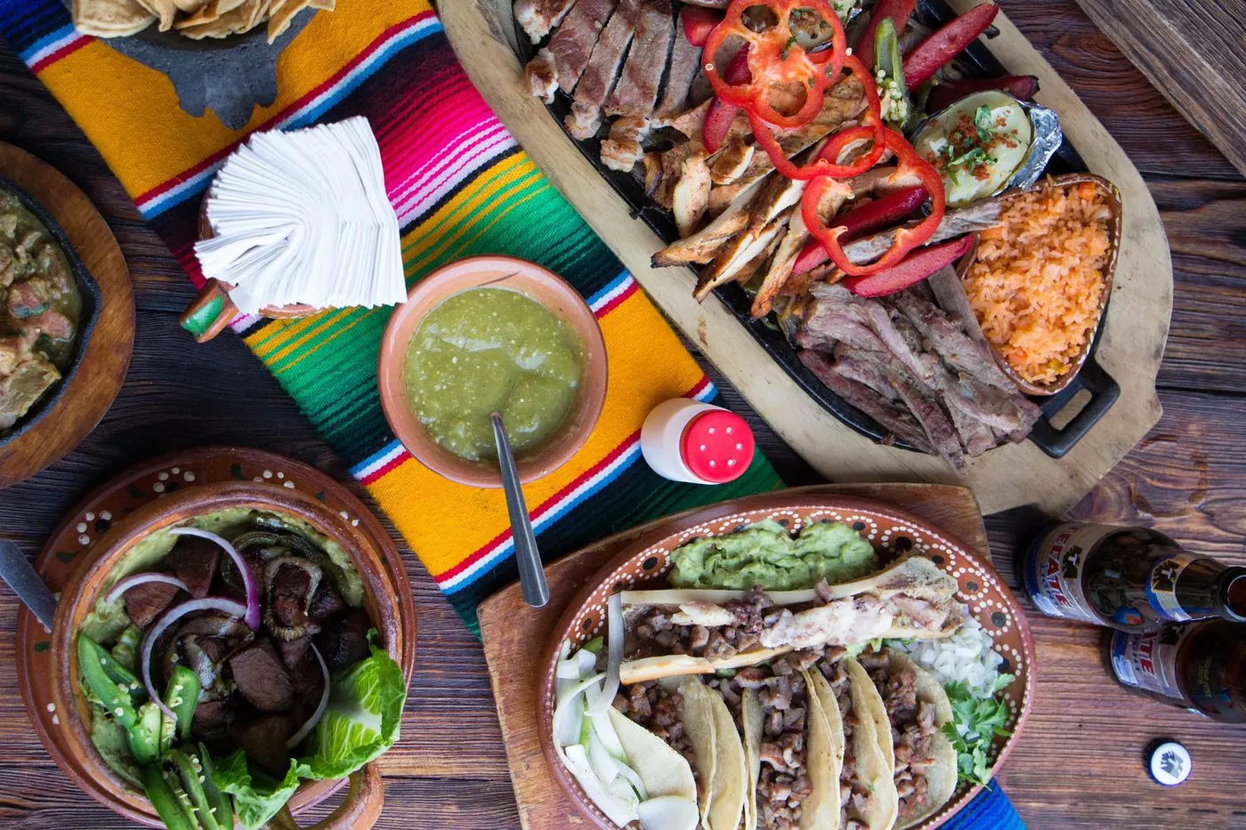 Mesa de Los Frijoles con parrillada, tacos, salsa verde y totopos sobre sarape